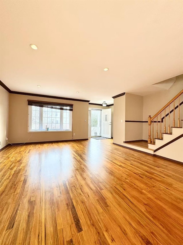 unfurnished living room with crown molding and light wood-type flooring