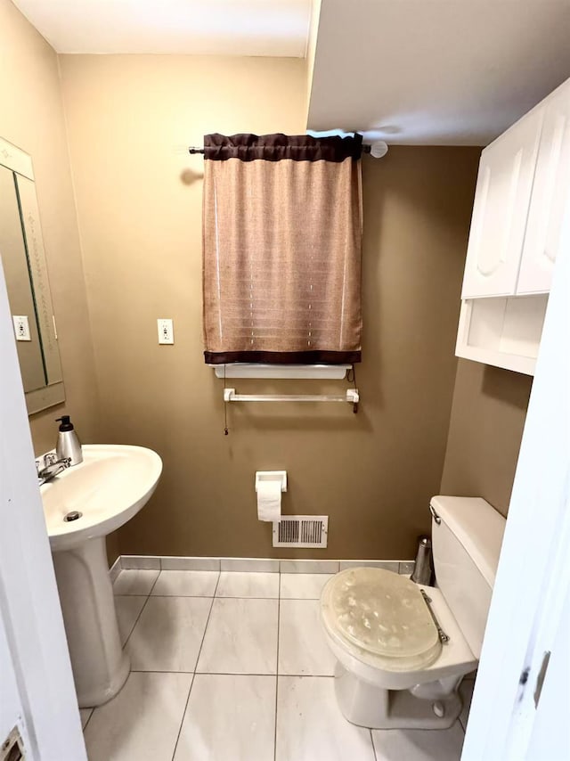 bathroom with toilet and tile patterned flooring