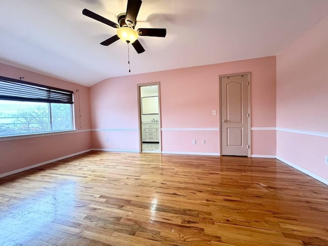 empty room with light hardwood / wood-style flooring, ceiling fan, and vaulted ceiling