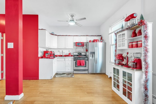 kitchen featuring ceiling fan, stainless steel appliances, tasteful backsplash, white cabinets, and light hardwood / wood-style flooring