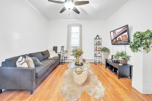 living room with ceiling fan, baseboard heating, and wood-type flooring