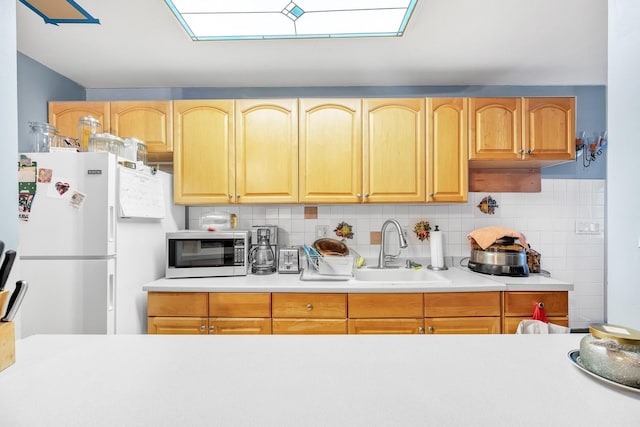 kitchen with white fridge, tasteful backsplash, and sink