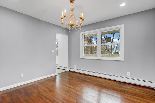 unfurnished room featuring baseboard heating, a notable chandelier, and hardwood / wood-style flooring