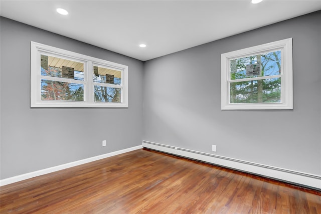 spare room featuring hardwood / wood-style flooring and baseboard heating