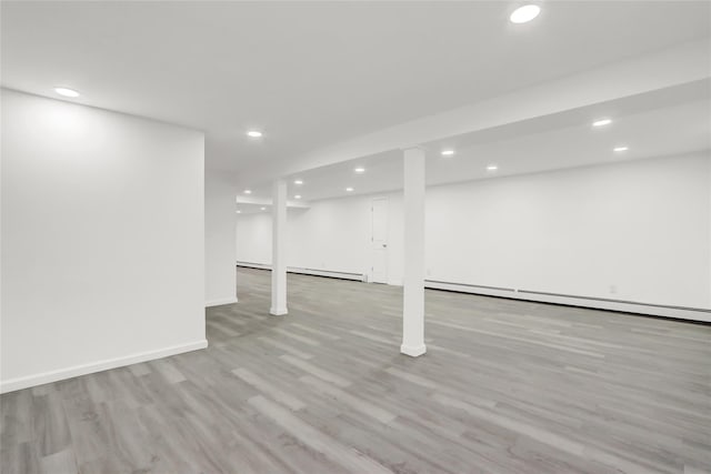 basement featuring a baseboard radiator and light wood-type flooring