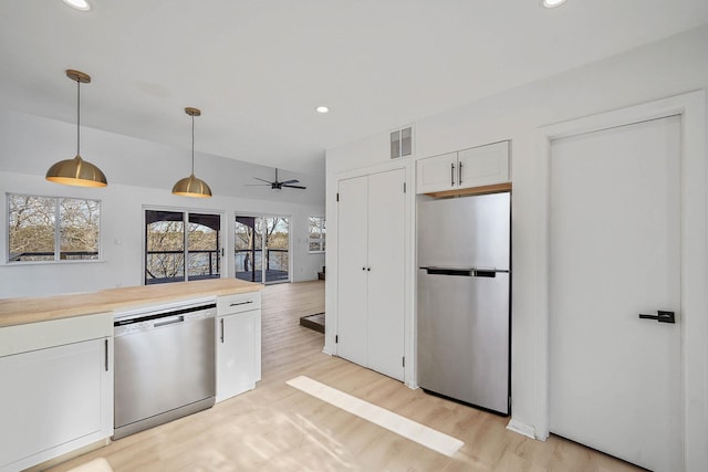 kitchen with ceiling fan, pendant lighting, stainless steel appliances, white cabinets, and wood counters