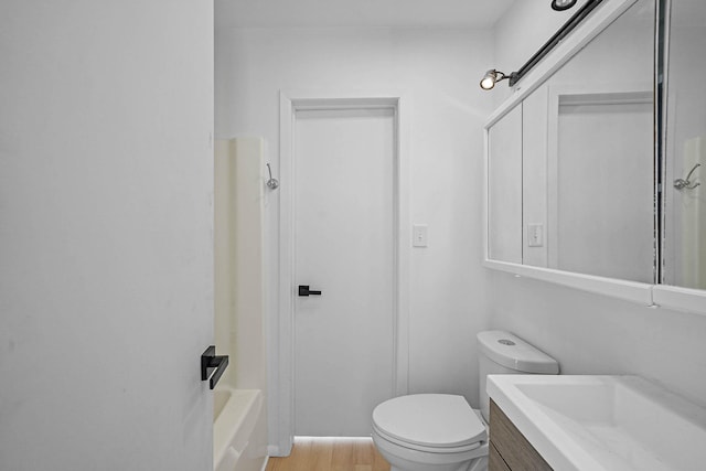 full bathroom with toilet, vanity, hardwood / wood-style floors, and washtub / shower combination