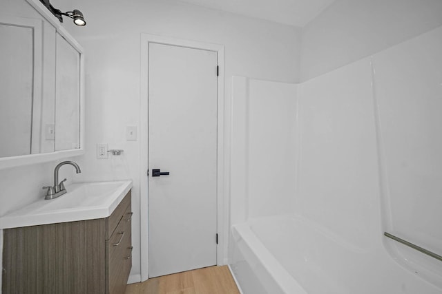 bathroom with shower / bath combination, hardwood / wood-style floors, and vanity