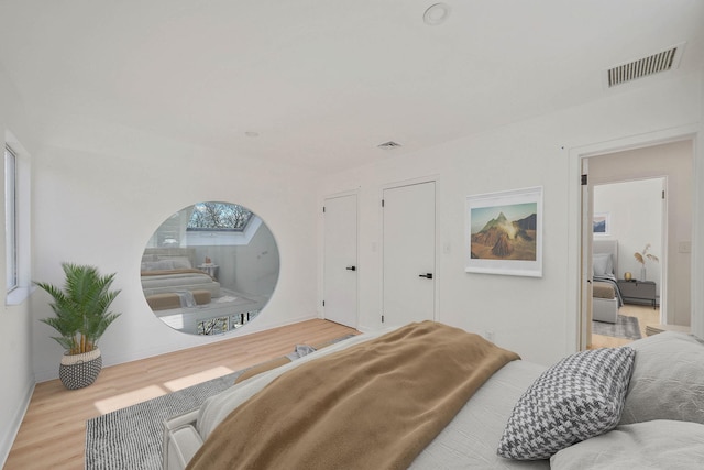 bedroom with light hardwood / wood-style flooring and a skylight