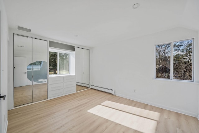 unfurnished bedroom with light hardwood / wood-style floors and baseboard heating