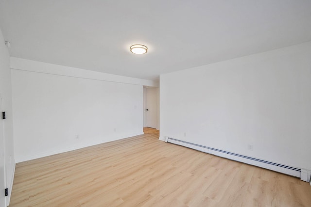 unfurnished room featuring light hardwood / wood-style floors and baseboard heating