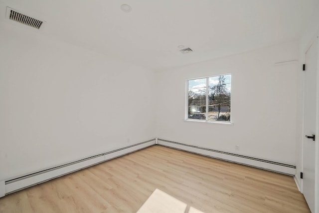 unfurnished room featuring light wood-type flooring and baseboard heating