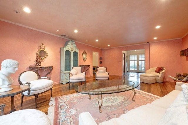 living room featuring wood-type flooring, crown molding, and french doors