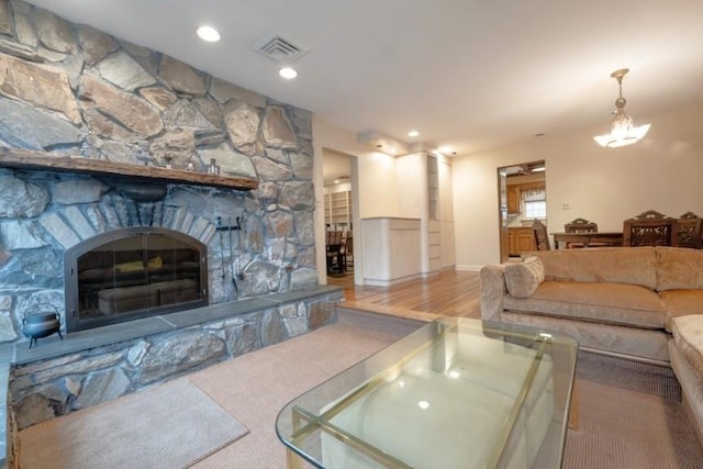 living room featuring a notable chandelier and a stone fireplace