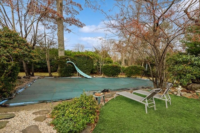 view of pool with a yard