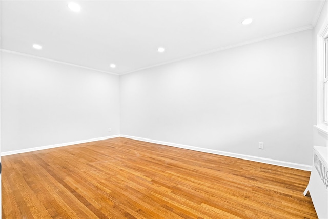 spare room with radiator, light hardwood / wood-style flooring, and ornamental molding