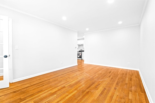 spare room featuring ornamental molding and light hardwood / wood-style floors