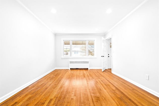 unfurnished room featuring ornamental molding, radiator heating unit, and light hardwood / wood-style flooring