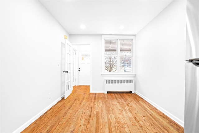 interior space with radiator heating unit and light hardwood / wood-style floors