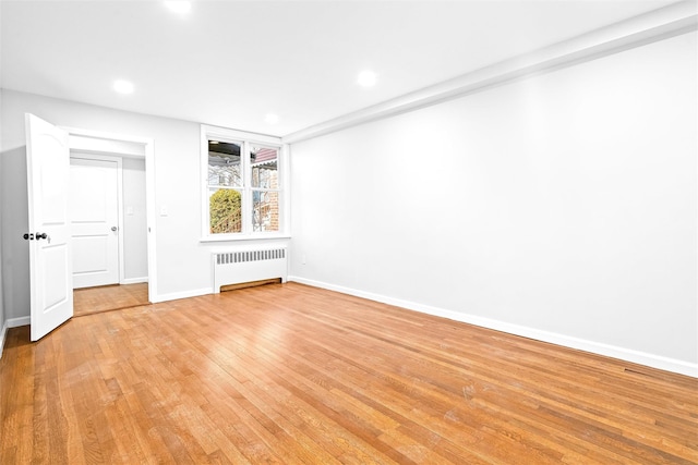 spare room with radiator and light hardwood / wood-style floors