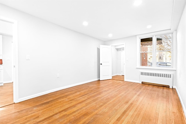 unfurnished bedroom with radiator heating unit and light hardwood / wood-style flooring