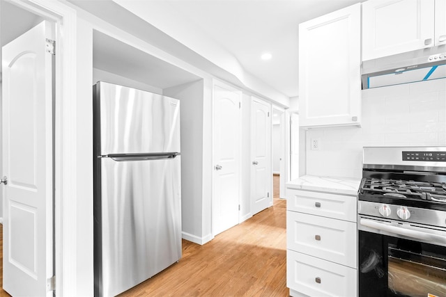 kitchen featuring backsplash, white cabinets, light stone counters, light hardwood / wood-style floors, and stainless steel appliances