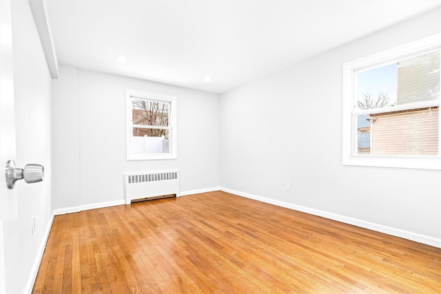 empty room with radiator and light wood-type flooring