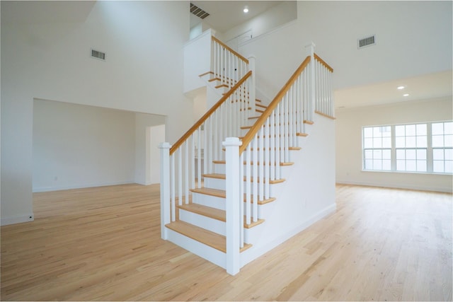 staircase with wood finished floors and visible vents