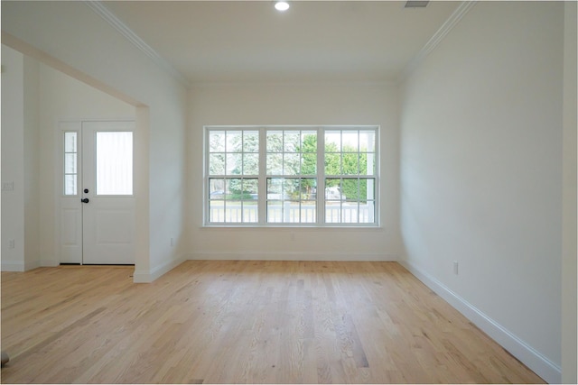 foyer featuring baseboards, light wood-type flooring, and ornamental molding