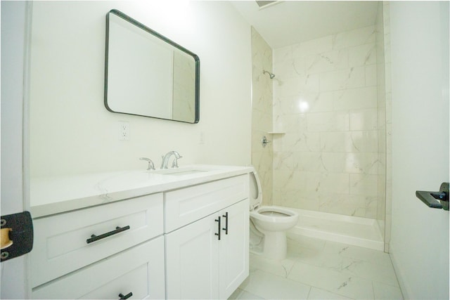 bathroom featuring marble finish floor, vanity, a shower stall, and toilet