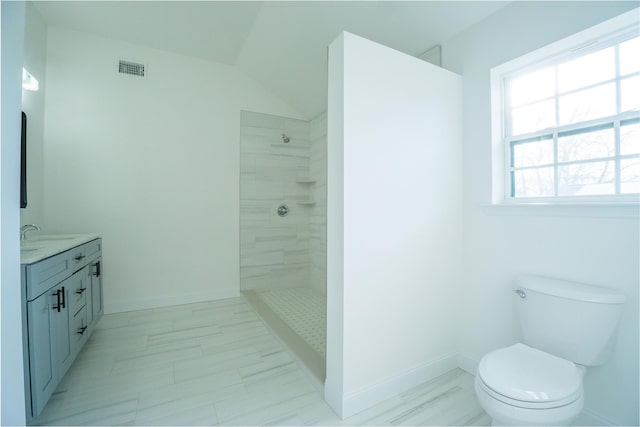 full bath with vanity, baseboards, visible vents, a tile shower, and toilet