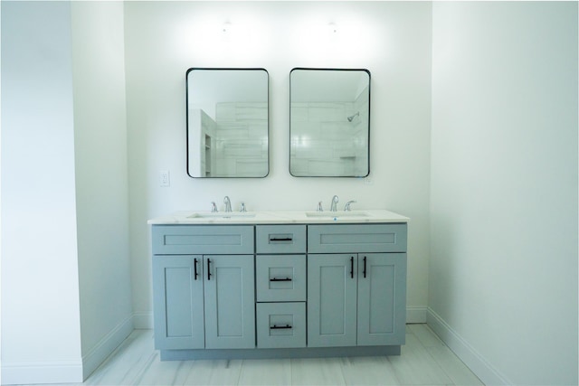 bathroom with a sink, baseboards, and double vanity