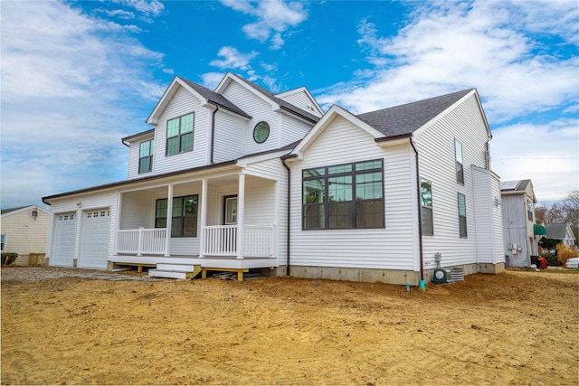 view of front of property with a porch, cooling unit, and an attached garage