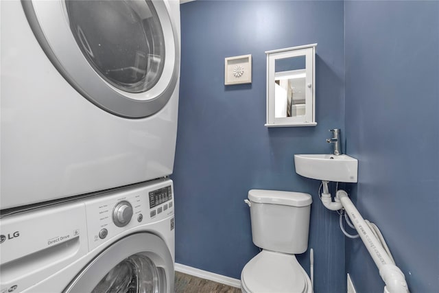 laundry area featuring sink, hardwood / wood-style flooring, and stacked washer / dryer