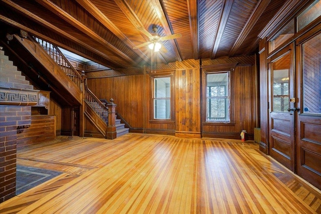 foyer featuring ceiling fan, hardwood / wood-style floors, wood ceiling, and wooden walls