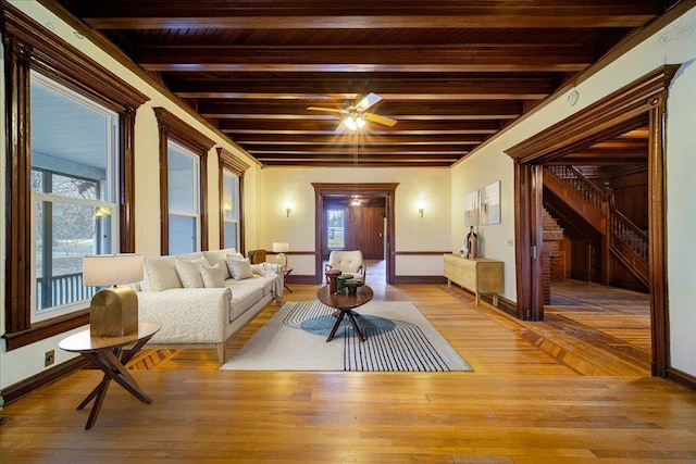 living room featuring beamed ceiling and light wood-type flooring