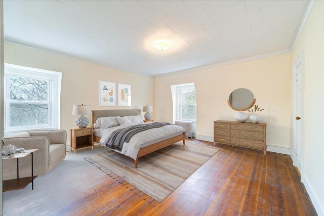 bedroom with ornamental molding, dark hardwood / wood-style flooring, and radiator