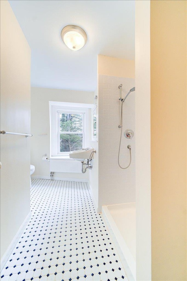 bathroom with tiled shower and toilet