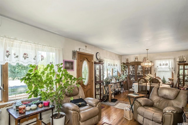 living room with hardwood / wood-style flooring, plenty of natural light, and a notable chandelier