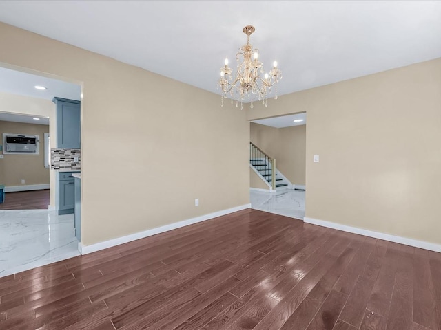 unfurnished room with an AC wall unit, dark hardwood / wood-style flooring, and an inviting chandelier