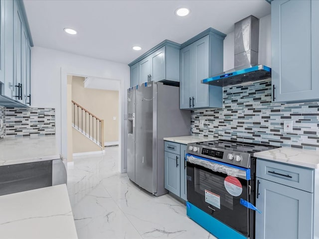 kitchen with wall chimney exhaust hood, backsplash, light stone countertops, and appliances with stainless steel finishes