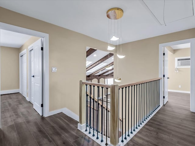 hallway with dark wood-type flooring, beamed ceiling, and an AC wall unit