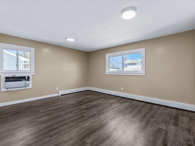 spare room featuring dark wood-type flooring and a wall mounted air conditioner