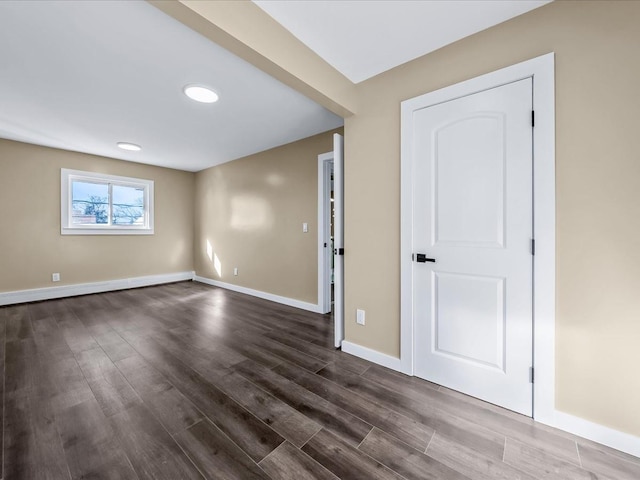 unfurnished room with dark wood-type flooring