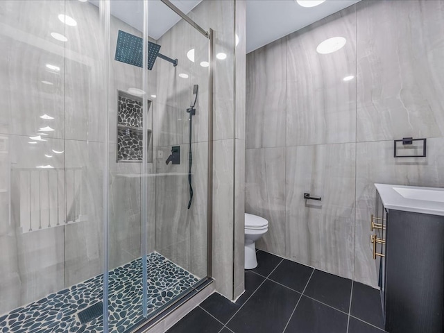 bathroom featuring tile patterned floors, toilet, tile walls, and vanity