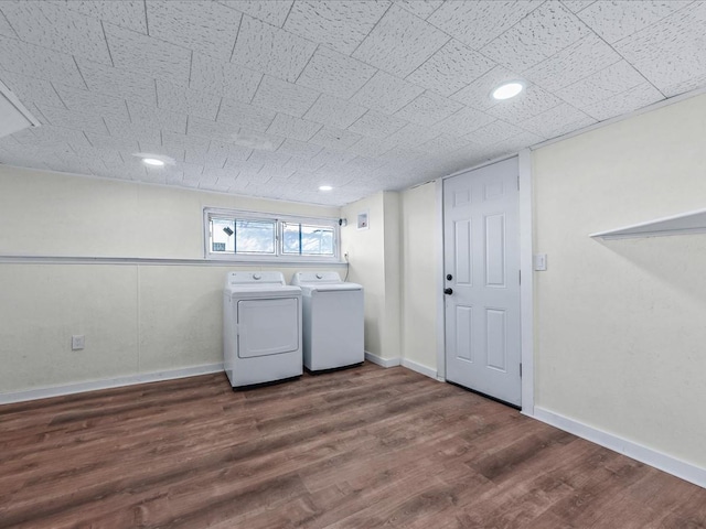 clothes washing area with dark hardwood / wood-style floors and washing machine and dryer