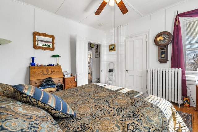 bedroom featuring ceiling fan, radiator, and hardwood / wood-style floors