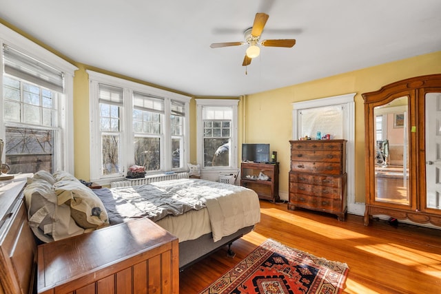 bedroom featuring multiple windows, ceiling fan, and light hardwood / wood-style flooring