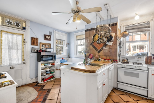 kitchen featuring white cabinetry, sink, backsplash, kitchen peninsula, and white appliances