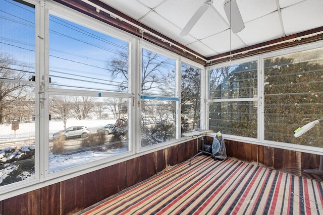 unfurnished sunroom featuring ceiling fan and a drop ceiling